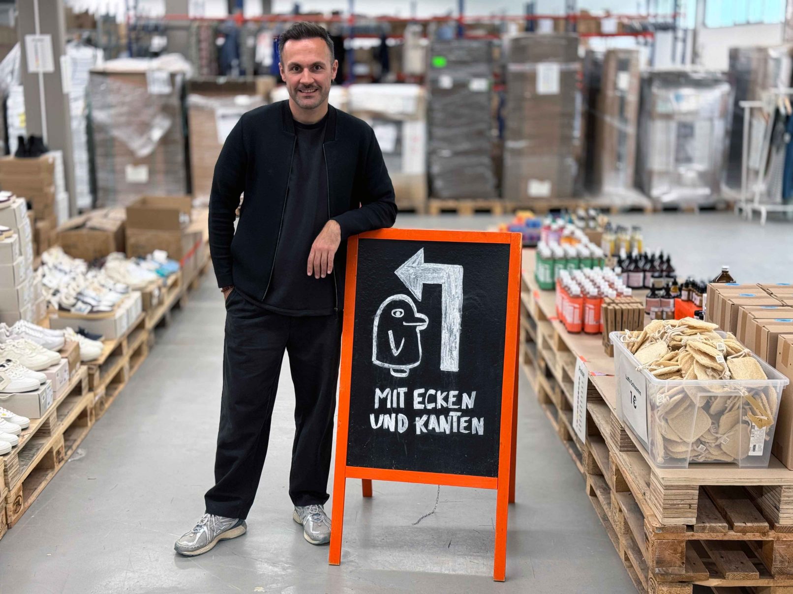 Mann steht in einer Lagerhalle